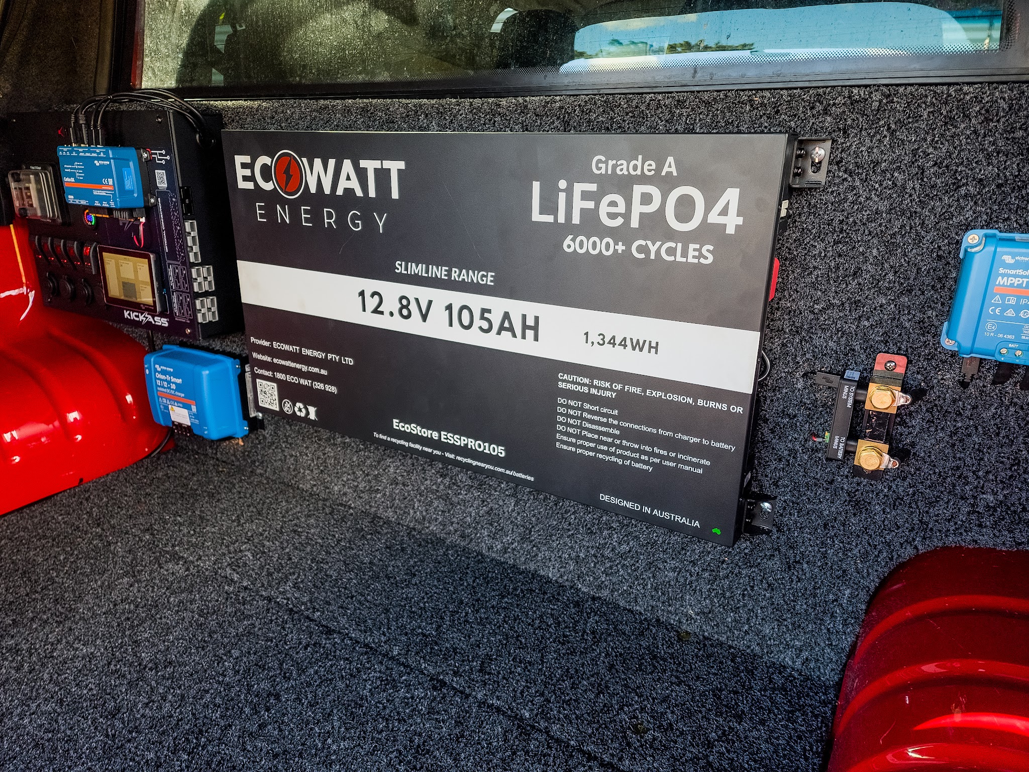 Close-up of a canopy 12 volt system, showing the switch panel, a DC-DC charger, a solar controller and a lithium battery